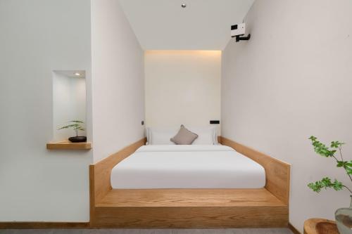 a bed in a room with white walls at Chongqing Xiannv Mount Peach Blossom Spring Homest in Wulong