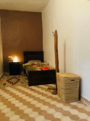 a bedroom with a bed and a table in a room at منزل للكراء بطابع مغربي تقليدي in Tamellalt