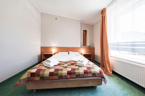 a bedroom with a bed and a window at Hotel Sobieszewo in Gdańsk