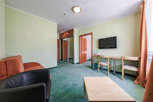 a living room with a couch and a table at Hotel Sobieszewo in Gdańsk