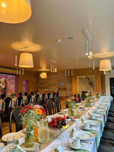 a long table in a room with chairs and flowers at MDS Wielichowo in Wielichowo