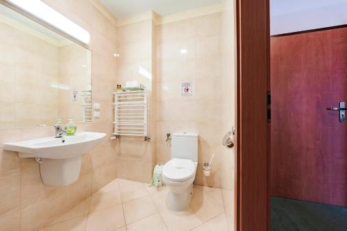 a bathroom with a white toilet and a sink at Hotel Sobieszewo in Gdańsk