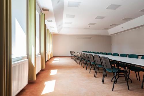 a conference room with a long table and chairs at Hotel Sobieszewo in Gdańsk