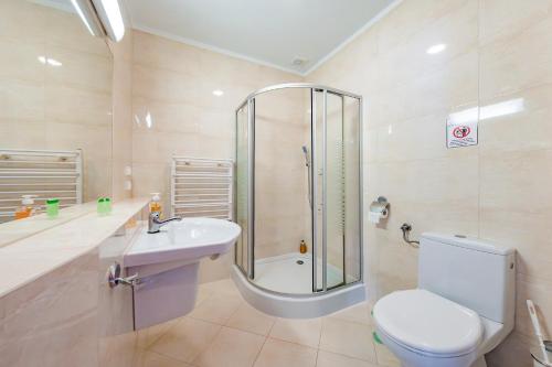 a bathroom with a shower and a toilet and a sink at Hotel Sobieszewo in Gdańsk