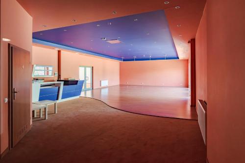 a large room with a blue ceiling and a kitchen at Hotel Sobieszewo in Gdańsk