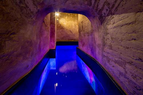a tunnel with blue and purple lights in a cave at Palazzo Bontadosi Hotel & Spa in Montefalco