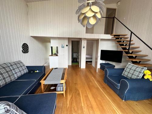 a living room with blue couches and a staircase at Privaatne saunamajaga suvila Peipsi kaldal in Katase
