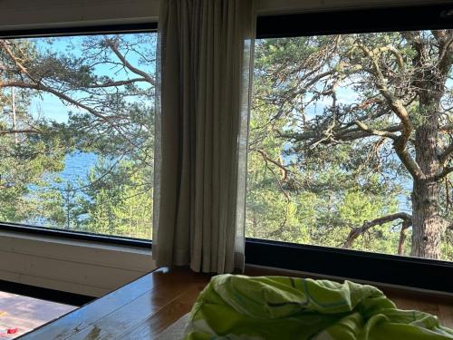 a bedroom with two large windows looking out at a tree at Privaatne saunamajaga suvila Peipsi kaldal in Katase