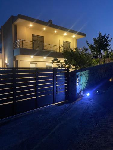 a house with a gate in front of it at night at Villa aspri petra rhodes in Rhodes Town