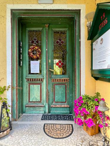 a green door with flowers in front of it at Landhaus HALLSTATT FEELING - Apartment - Self Check-in in Bad Goisern