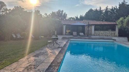 une piscine dans une cour à côté d'une maison dans l'établissement Gite de charme, à Puyméras