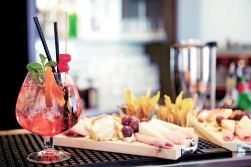 a table with a wine glass and a plate of food at Mercure Roma Piazza Bologna in Rome
