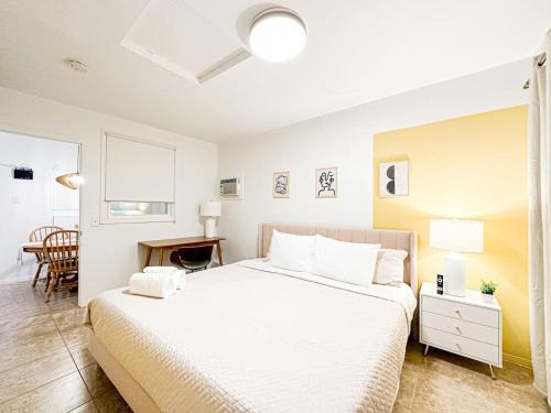 a bedroom with a large white bed and a desk at Relaxed and Cozy Poolside Studio - LOU2 - BUR in Burbank