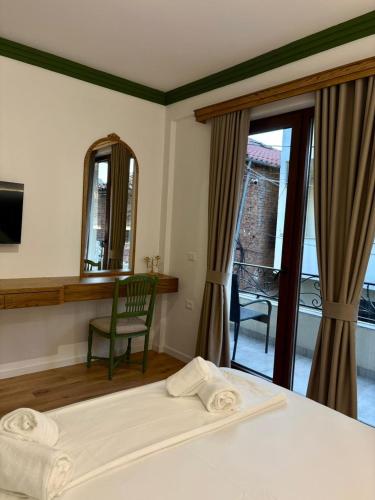 a bedroom with a bed and a mirror and a chair at Tomas Inn in Pogradec