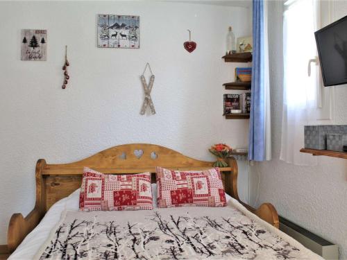 une chambre avec un lit avec des oreillers rouges et blancs dans l'établissement Studio confortable avec balcon près des pistes, 4 couchages - Risoul 1850 - FR-1-330-496, à Risoul
