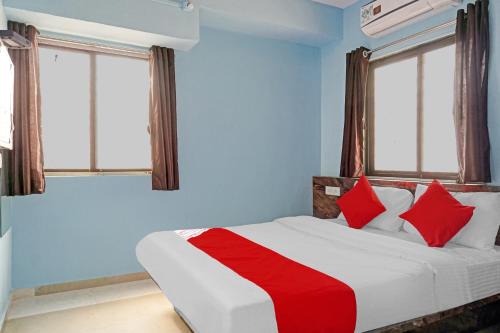 a bedroom with a bed with red pillows and windows at Hotel O Way Point in Méribel Village