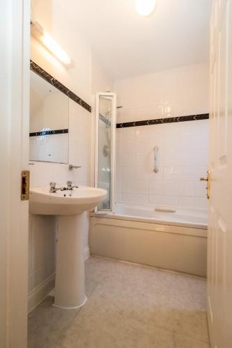 a white bathroom with a sink and a bath tub at Aughrim Holiday Village No 6 by Trident Holiday Homes in Aughrim