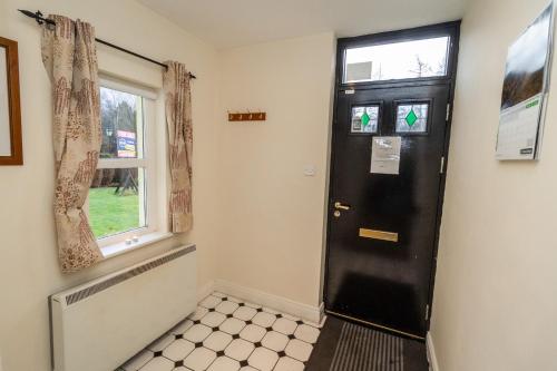 a black door in a room with a window at Aughrim Holiday Village No 6 by Trident Holiday Homes in Aughrim