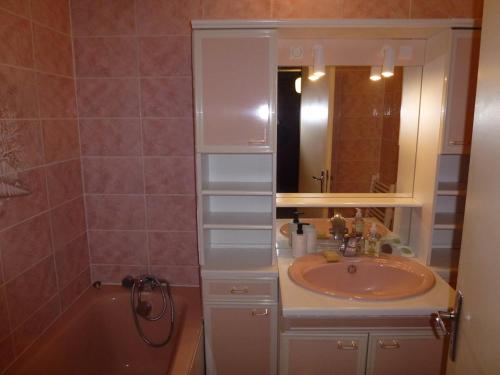 ein Badezimmer mit Waschbecken, Spiegel und Badewanne in der Unterkunft Appartement lumineux au pied des pistes avec WiFi - FR-1-292-173 in Isola