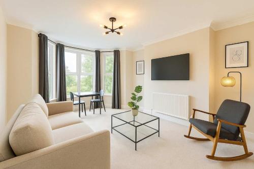 a living room with a couch and a table at Central King Apartment with view of River in Cardiff