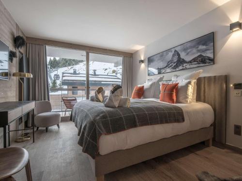 谷雪维尔Appartement au centre de Courchevel 1550, 6/7 pers, Wi-Fi, parking, accès spa - FR-1-631-198的一间带大床和大窗户的卧室