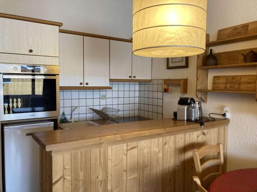 - une cuisine avec un comptoir en bois clair dans l'établissement Appartement cosy 6 pers, centre Alpe d'Huez, proche pistes/activités, balcon sud - FR-1-405-359, à Huez