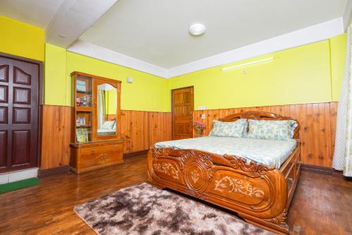 a bedroom with a wooden bed and yellow walls at sunset nest Drokpas rest heart of Darjeeling in Darjeeling