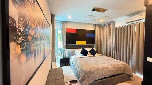 a bedroom with a bed and a large painting on the wall at De Flourishing Hill Escape, Cha Am in Ban Hup Kaphong