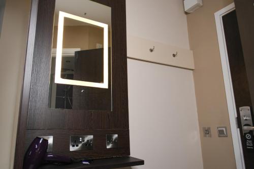 a mirror on a wall in a room at Coach & Horses Hotel in Cardiff