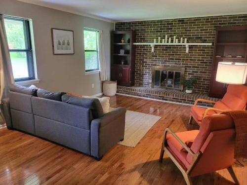 a living room with a couch and a fireplace at Country Lane Cottage- privacy & quiet neighborhood in Rossville