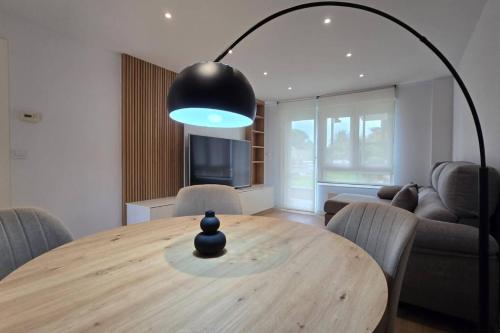 a dining room with a wooden table and a large light fixture at Suances Brisa Del Cantábrico in Suances