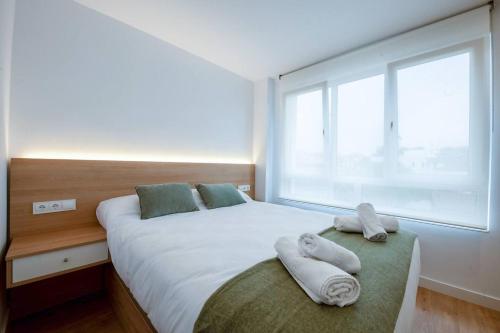 a bedroom with two towels on a bed with a window at Suances Brisa Del Cantábrico in Suances