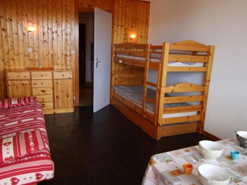 une chambre avec deux lits superposés et une table dans l'établissement Studio confortable aux Saisies pour 4 personnes avec balcon et cuisine équipée - FR-1-594-127, à Hauteluce