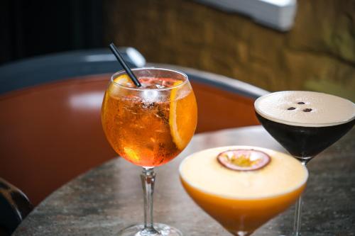 two cocktails are sitting on a table at Coach & Horses Hotel in Cardiff
