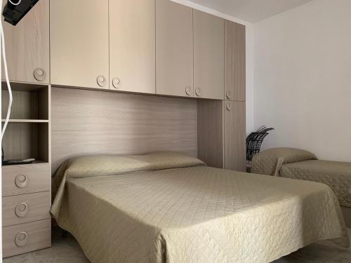a bedroom with two beds and a cabinet at La Depandance in Porto Cesareo