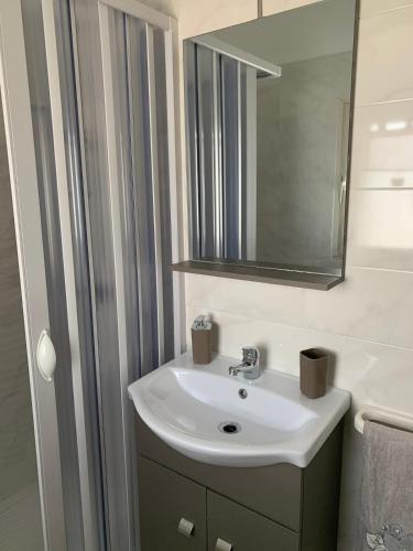 a bathroom with a white sink and a mirror at La Depandance in Porto Cesareo