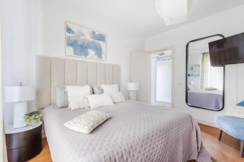 a white bedroom with a large bed with a mirror at The Secret Escape Villa in Sant' Alessio