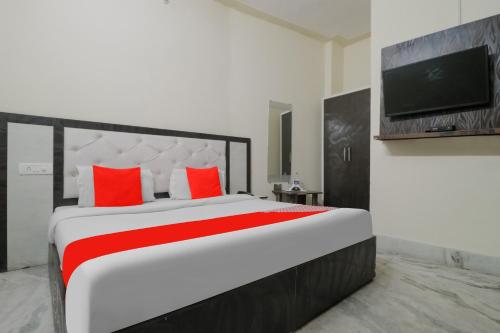 a bedroom with a bed with red pillows and a tv at Hotel O Hc Plaza in Kharar