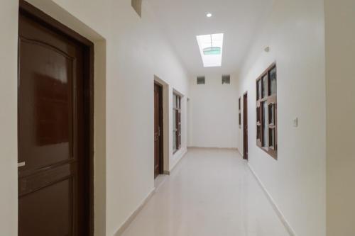 an empty corridor in a building with doors at Hotel O Hc Plaza in Kharar