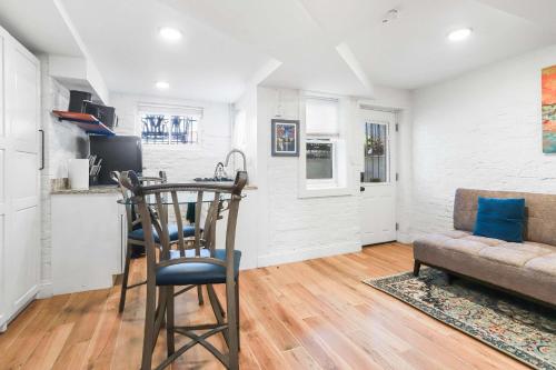 a kitchen and living room with a table and a chair at Sojourn Charming Lower Level Studio - Capitol Hill in Washington, D.C.