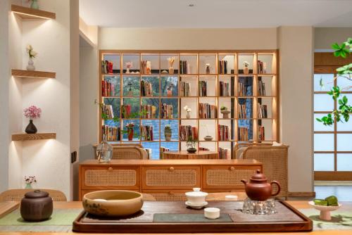 a room with a book shelf filled with books at Chongqing Xiannv Mount Peach Blossom Spring Homest in Wulong