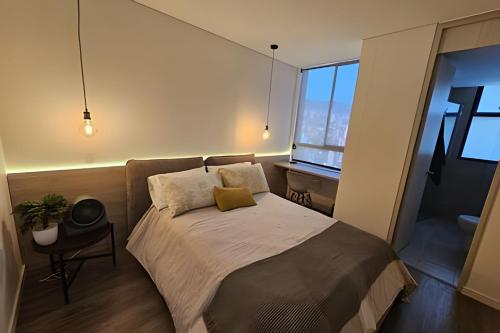 een slaapkamer met een bed, een bureau en een raam bij Parma 2305 - Elegance in the Urban Heart / Poblado in El Poblado