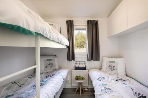two bunk beds in a small room with a window at TopParken – Parc IJsselhoeve in IJssellaan