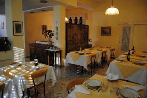 a dining room with tables and chairs with white tablecloths at Hotel Casa Diomira in Lido di Camaiore