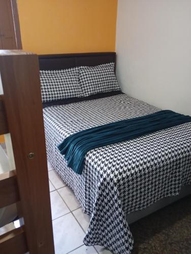 a bed with a black and white comforter on it at Trem Bão de Dormir in Recife