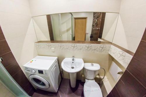 a bathroom with a sink and a toilet and a mirror at Хоум Отель на Домашникова, 22 in Ufa