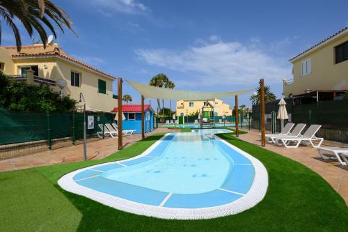 a swimming pool in the middle of a yard at Bungalow with Terrace BBQ Pool in Maspalomas in Maspalomas