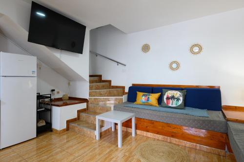 a living room with a couch and a staircase at Bungalow with Terrace BBQ Pool in Maspalomas in Maspalomas