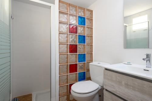 a bathroom with a toilet and a glass tile wall at Bungalow with Terrace BBQ Pool in Maspalomas in Maspalomas