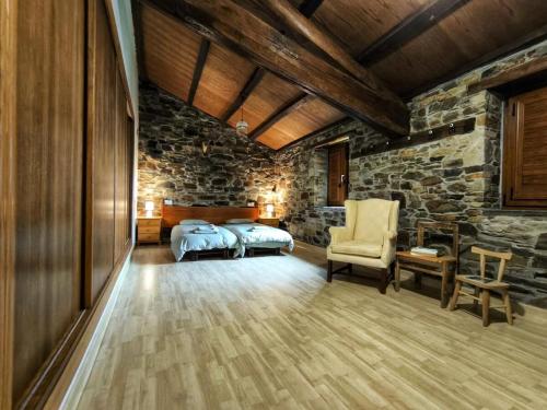 a bedroom with two beds and a stone wall at 39A01 La Casita Olga Casa en plena naturaleza in Arrojo